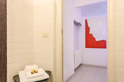 a bathroom with white towels and a red painting at Rome as you feel - Selci Apartment in Rome