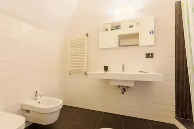 a white bathroom with a sink and a toilet at Rome as you feel - Selci Apartment in Rome