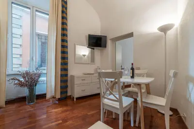 a dining room with a table and chairs and a mirror at CS Piazza Venezia Apartment in Rome