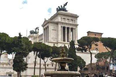 a fountain in front of a building with a statue at CS Piazza Venezia Apartment in Rome