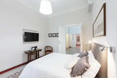 a white bedroom with a bed and a flat screen tv at Lovely House Rome in Rome