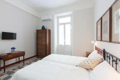 a white bedroom with two beds and a table at Lovely House Rome in Rome