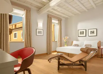 a hotel room with a bed and a chair at Palazzo Scanderbeg in Rome
