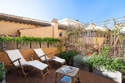 two chairs and a table on a patio with plants at Palazzo Scanderbeg in Rome