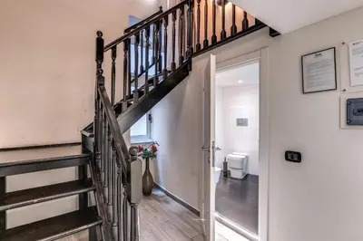 a hallway with a staircase leading to a bathroom with a toilet at Operà Suites Pinciana in Rome