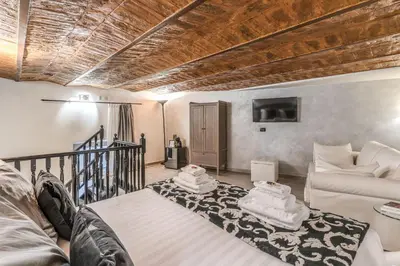 a living room with a bed and a couch at Operà Suites Pinciana in Rome