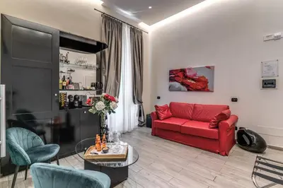 a living room with a red couch and a table at Operà Suites Pinciana in Rome