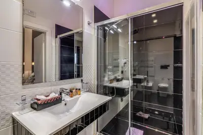 a bathroom with a sink and a shower at Operà Suites Pinciana in Rome