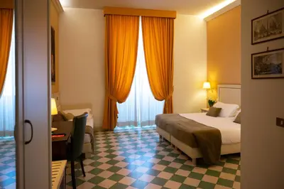 a hotel room with a bed and a desk at Basilica Hotel in Rome