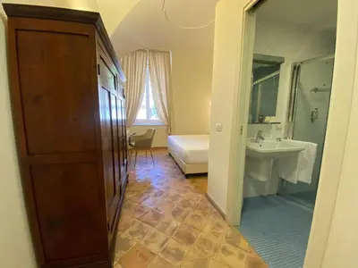 a bathroom with a bed and a sink in a room at Basilica Hotel in Rome