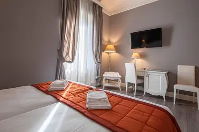 a bedroom with a bed with an orange blanket on it at Domus Castrense in Rome