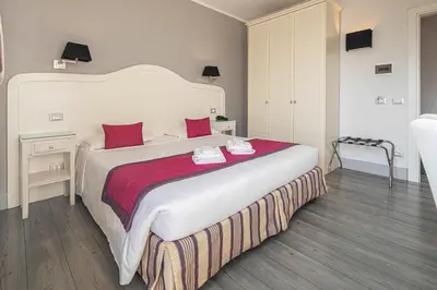 a bedroom with a large white bed with red pillows at Domus Castrense in Rome