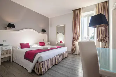 a bedroom with a large white bed with red pillows at Domus Castrense in Rome