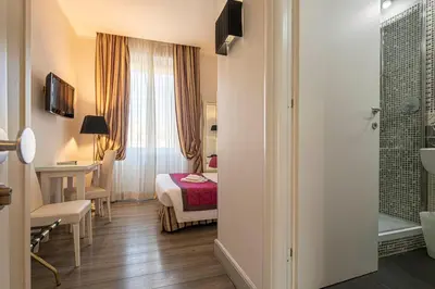 a hotel room with a bed and a bathroom at Domus Castrense in Rome