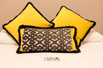 two yellow pillows sitting on a bed at MyBedCavour in Rome