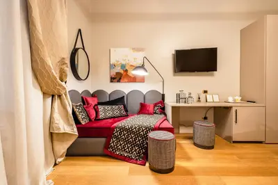 a bedroom with a bed with red pillows and a desk at MyBedCavour in Rome