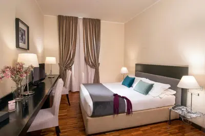 a hotel room with a bed and a desk with a computer at Suitedreams in Rome