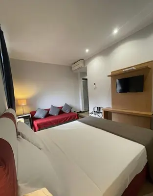 a hotel room with two beds and a flat screen tv at Residenza Cola Di Rienzo - Suite In Rome in Rome