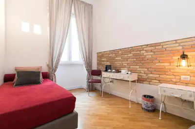 a bedroom with a red bed and a brick wall at Spagna Ave in Rome