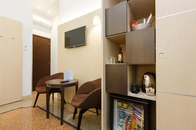 a room with a refrigerator and a table with chairs at Domus Terenzio in Rome