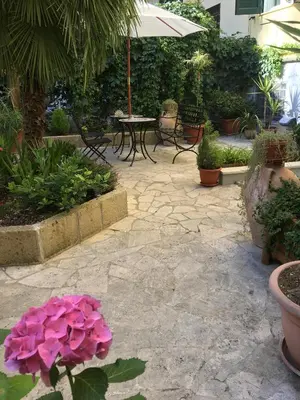a patio with a table and pink flowers at Domus Terenzio in Rome