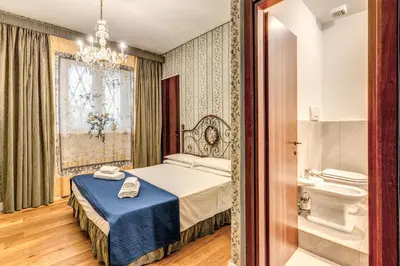 a bedroom with a bed and a bathroom with a toilet at Residenza Ave Roma in Rome