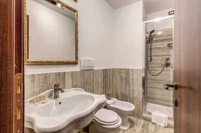 a bathroom with a sink and a toilet and a mirror at Residenza Ave Roma in Rome