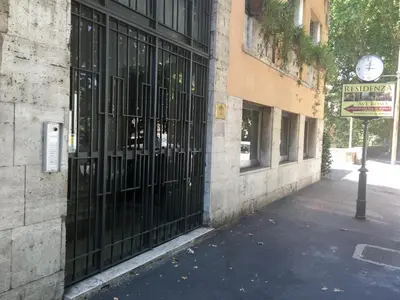 a building with a black gate and a clock on it at Residenza Ave Roma in Rome