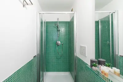 a bathroom with a shower with green tiles at Residenza Vaticana in Rome