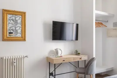 a room with a desk and a tv on a wall at Residenza Vaticana in Rome