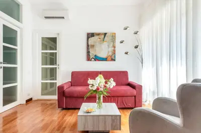 a red couch in a living room with a table at HOME SWEET HOLIDAY srl in Rome