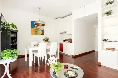 a kitchen and dining room with white cabinets and a table and chairs at HOME SWEET HOLIDAY srl in Rome