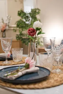 a table with a blue plate with a vase with a flower in it at MoMo Vatican Museums in Rome