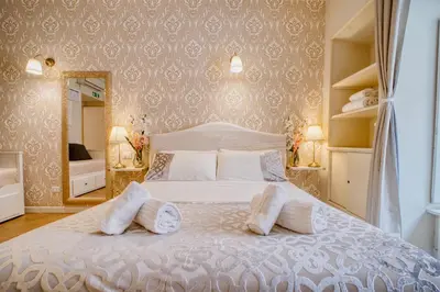a bedroom with a white bed and a mirror at MoMo Vatican Museums in Rome