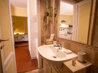 a bathroom with a sink and a kitchen at Navona Little Home in Rome