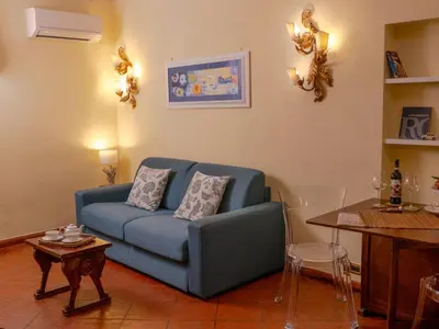 a living room with a blue couch and a table at Navona Little Home in Rome