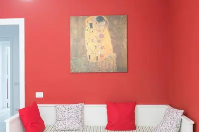 a room with a red wall with a couch and a painting at Domus Klimt in Rome