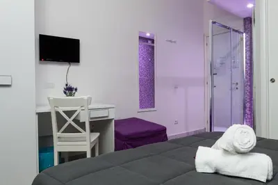a bedroom with a bed and a desk and a chair at Re di Luna B&B in Rome