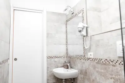 a white bathroom with a sink and a shower at Re di Luna B&B in Rome