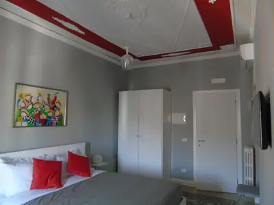 a bedroom with a bed with red pillows at Room Inn Vatican in Rome