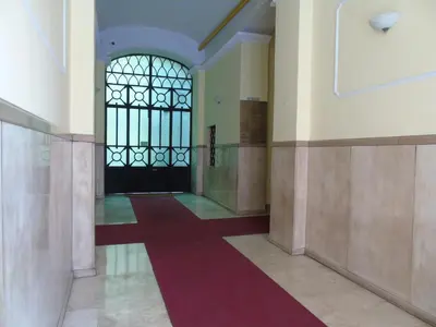 a hallway with a door and a red carpet at Room Inn Vatican in Rome