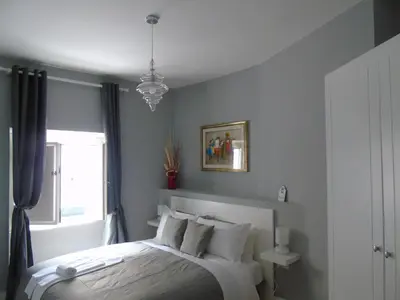 a bedroom with a bed and a window and a chandelier at Room Inn Vatican in Rome