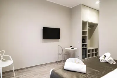 a white room with a bed and a tv on a wall at Aeterno Eco Guest House in Rome
