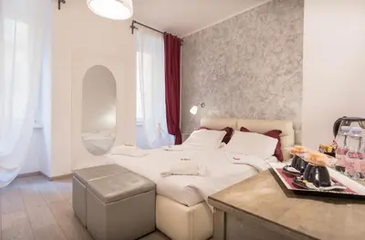 a bedroom with a bed and a table and a sink at Your Vatican Suite in Rome