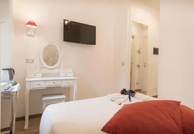 a bedroom with a bed and a tv on the wall at Your Vatican Suite in Rome