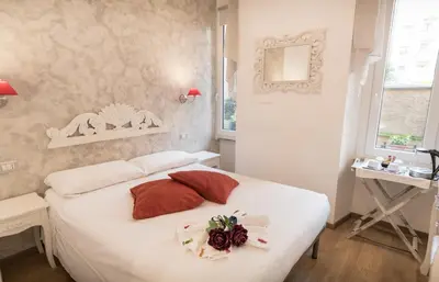a bedroom with a white bed with a flower on it at Your Vatican Suite in Rome