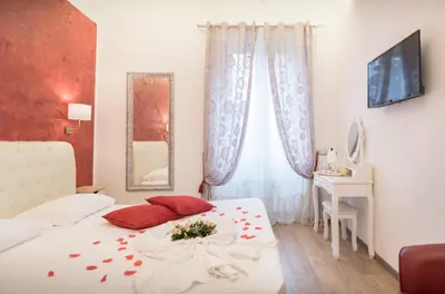 a bedroom with a white bed with red pillows at Your Vatican Suite in Rome