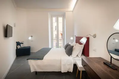 a bedroom with a bed and a desk and a mirror at Your Vatican Suite in Rome
