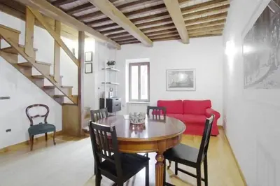 a living room with a table and a red couch at Casa Paradiso in Rome