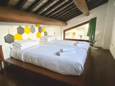 a bedroom with two large beds with yellow and white pillows at Casa Paradiso in Rome